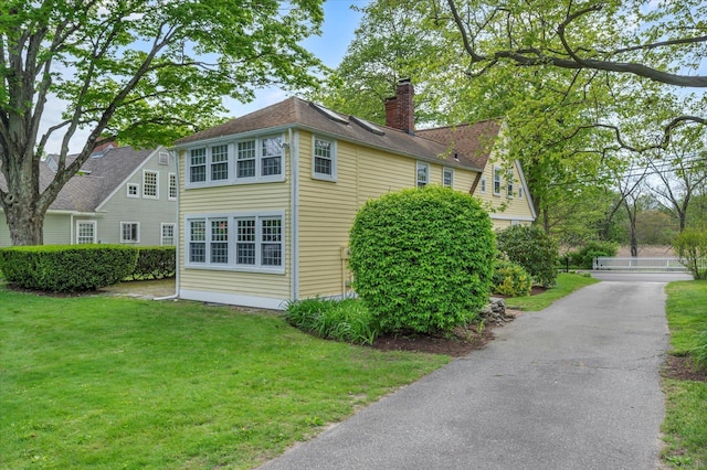 view of home's exterior with a yard and a chimney