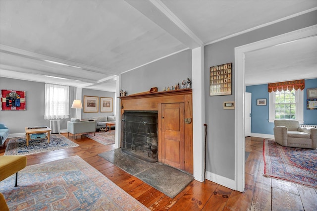 living area with radiator heating unit, hardwood / wood-style floors, a fireplace, and baseboards