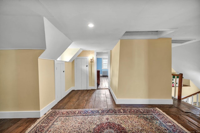 additional living space featuring radiator, hardwood / wood-style flooring, baseboards, and recessed lighting
