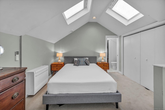 bedroom with a skylight, light colored carpet, lofted ceiling, and a closet