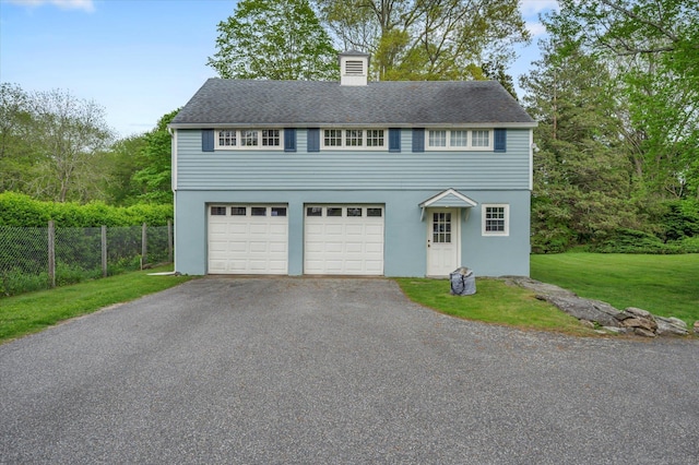 view of front of house featuring asphalt driveway, a chimney, stucco siding, and a garage