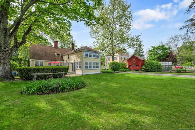 back of house with a lawn and a chimney