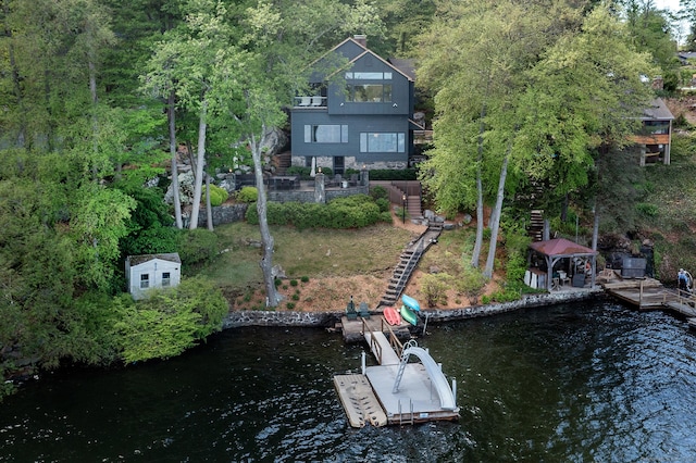 back of property featuring stairway and a water view
