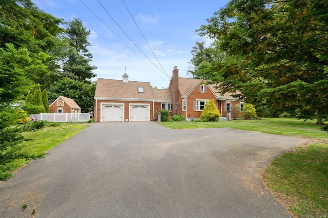 717 Center St, Manchester, CT 06040 - view of front of property featuring asphalt driveway, a garage, and a chimney