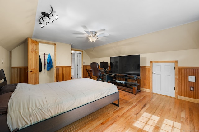 717 Center St, Manchester, CT 06040 - bedroom with wainscoting, lofted ceiling, wooden walls, light wood finished floors, and a spacious closet
