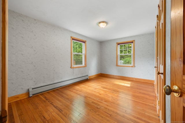 717 Center St, Manchester, CT 06040 - empty room featuring baseboard heating, light wood-style floors, and baseboards