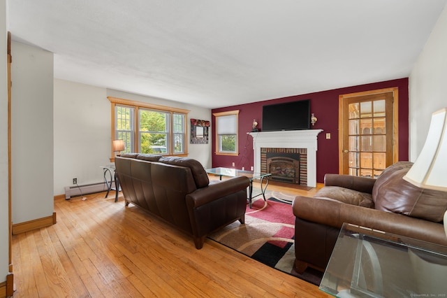 717 Center St, Manchester, CT 06040 - living area with a baseboard heating unit, light wood finished floors, a fireplace, and baseboards