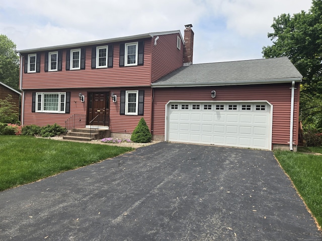 166 Kennedy Rd, Manchester, CT 06042 - colonial inspired home featuring driveway, a chimney, a garage, and a front lawn