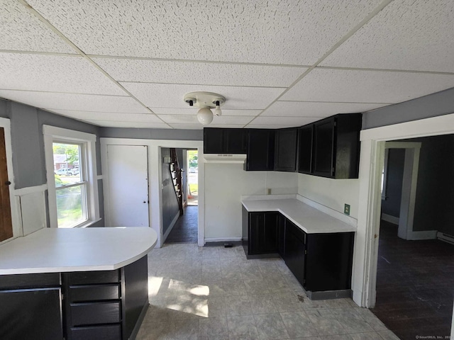 827 Middle Tpke E, Manchester, CT 06040 - kitchen with dark cabinetry, a drop ceiling, and light countertops