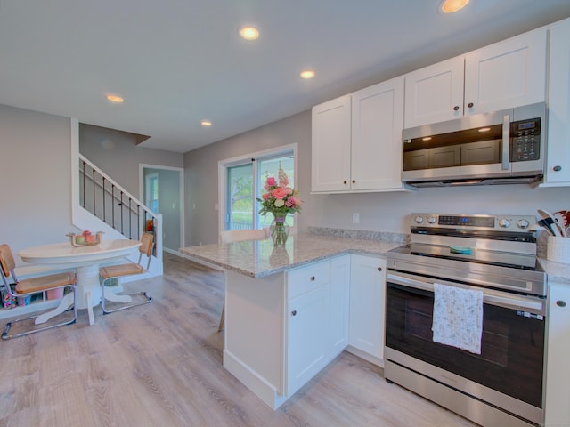 1026 Rte 171, Woodstock, CT 06281 - kitchen with stainless steel appliances, a peninsula, white cabinets, light stone countertops, and recessed lighting
