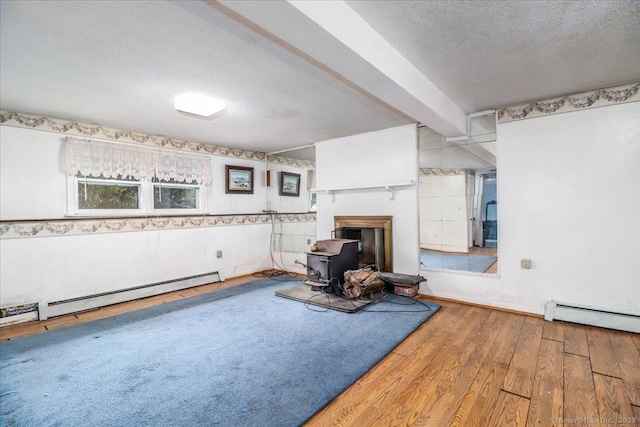 31 Branch Hill Rd, Preston, CT 06365 - living area featuring a baseboard heating unit, a wood stove, wood finished floors, a textured ceiling, and beam ceiling