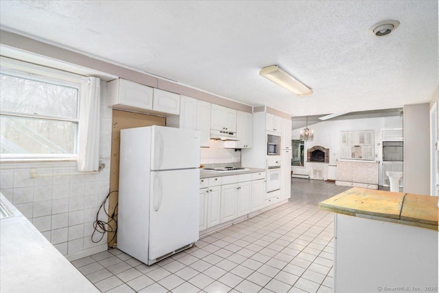 31 Branch Hill Rd, Preston, CT 06365 - kitchen with white appliances, under cabinet range hood, light countertops, light tile patterned flooring, and a textured ceiling