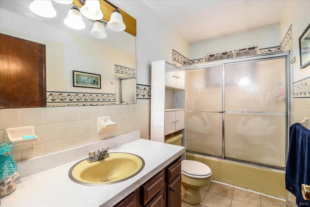 31 Branch Hill Rd, Preston, CT 06365 - bathroom with tile patterned flooring, vanity, bath / shower combo with glass door, toilet, and tile walls