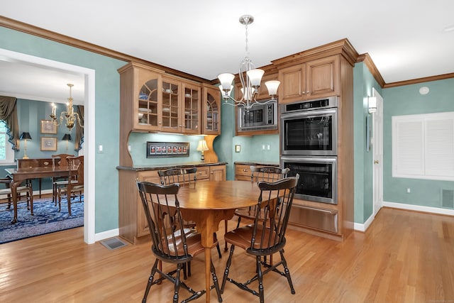 116 Thornbush Rd, Wethersfield, CT 06109 - dining room with a chandelier, light wood finished floors, ornamental molding, and baseboards