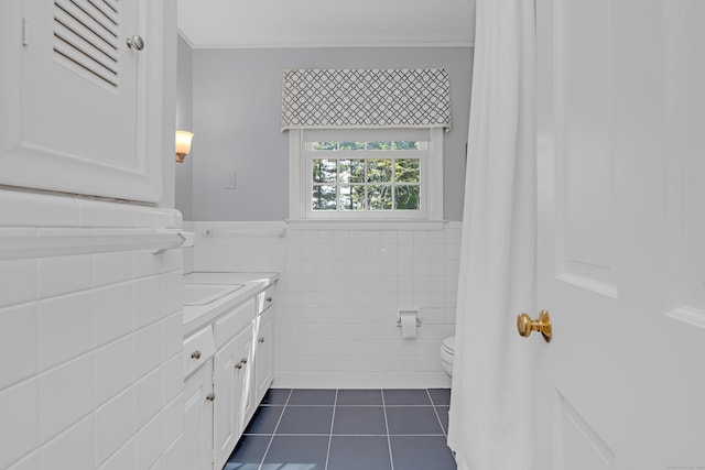 116 Thornbush Rd, Wethersfield, CT 06109 - bathroom with tile patterned flooring, tile walls, toilet, vanity, and a wainscoted wall