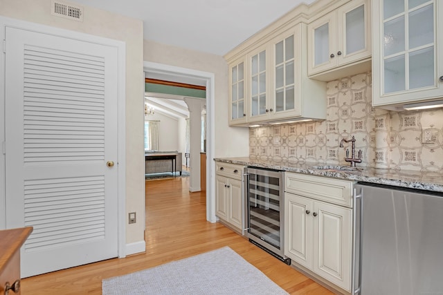 116 Thornbush Rd, Wethersfield, CT 06109 - kitchen with wine cooler, fridge, decorative backsplash, a sink, and light wood-type flooring