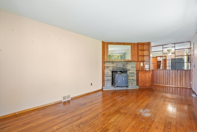 1 Cedar Rd, Danbury, CT 06811 - unfurnished living room with wood finished floors, baseboards, and a wood stove