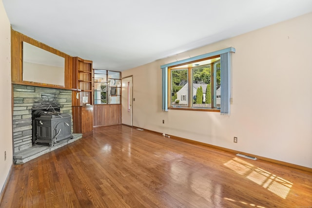 1 Cedar Rd, Danbury, CT 06811 - unfurnished living room featuring a wood stove, wood finished floors, and baseboards