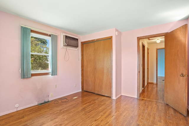 1 Cedar Rd, Danbury, CT 06811 - unfurnished bedroom featuring wood finished floors, an AC wall unit, baseboards, and a closet
