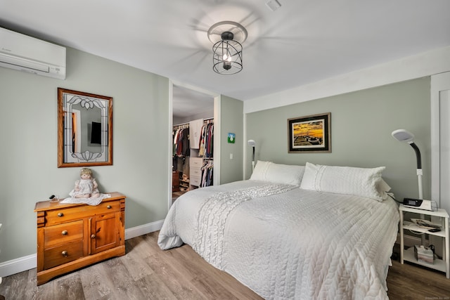 3 Lynns Corner Rd, Woodbury, CT 06798 - bedroom with an AC wall unit, wood finished floors, a walk in closet, and a closet