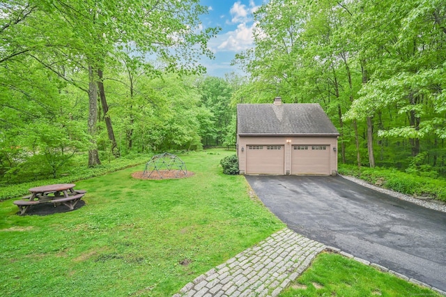 33 Erdoni Rd, Columbia, CT 06237 - view of green lawn with an outdoor structure, a garage, and a wooded view