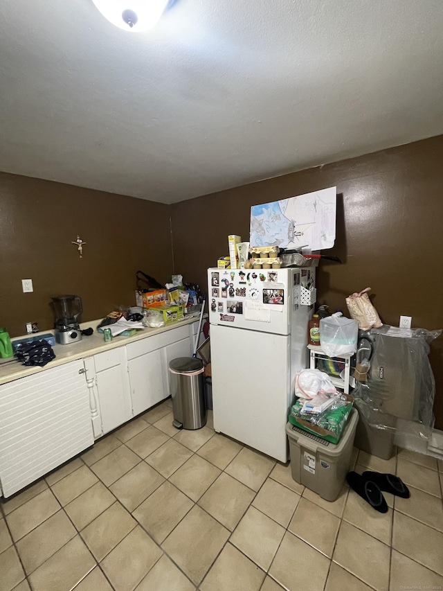1315 Hamilton Ave, Waterbury, CT 06706 - kitchen with freestanding refrigerator, light tile patterned flooring, white cabinetry, and light countertops