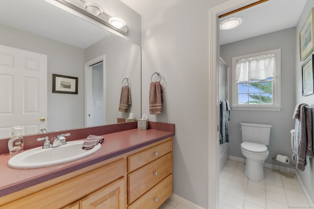 bathroom with toilet, vanity, tile patterned flooring, baseboards, and washtub / shower combination
