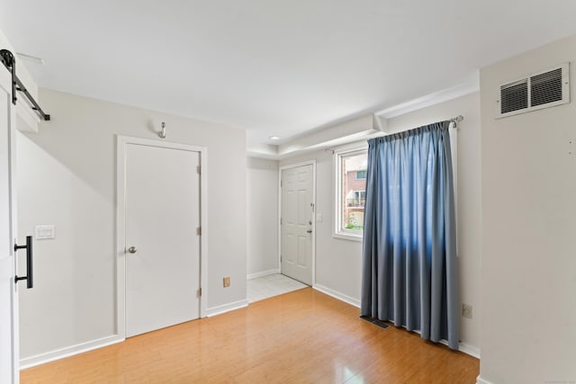 101 Grove St Apt 19, Stamford, CT 06901 - entryway with a barn door, light wood-type flooring, and baseboards