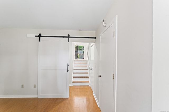 101 Grove St Apt 19, Stamford, CT 06901 - corridor featuring light wood-type flooring, a barn door, and baseboards