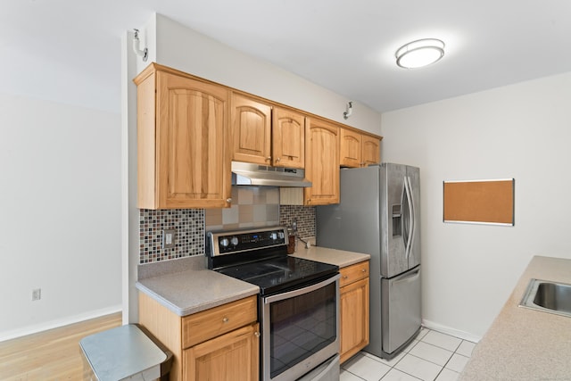 101 Grove St Apt 19, Stamford, CT 06901 - kitchen featuring appliances with stainless steel finishes, under cabinet range hood, tasteful backsplash, baseboards, and light countertops