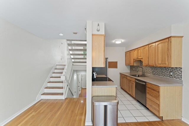 101 Grove St Apt 19, Stamford, CT 06901 - kitchen featuring stainless steel dishwasher, a sink, backsplash, baseboards, and light countertops
