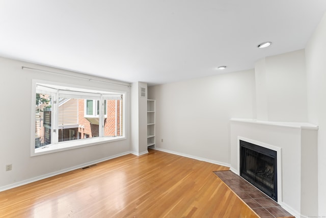 101 Grove St Apt 19, Stamford, CT 06901 - unfurnished living room with wood finished floors, a fireplace with flush hearth, baseboards, and recessed lighting