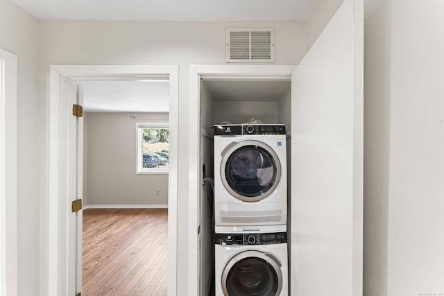 101 Grove St Apt 19, Stamford, CT 06901 - washroom with stacked washer / dryer, hardwood / wood-style floors, and baseboards