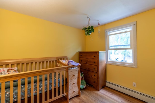 9 Berkshire Dr, East Hampton, CT 06424 - bedroom featuring baseboard heating, wood finished floors, and a nursery area