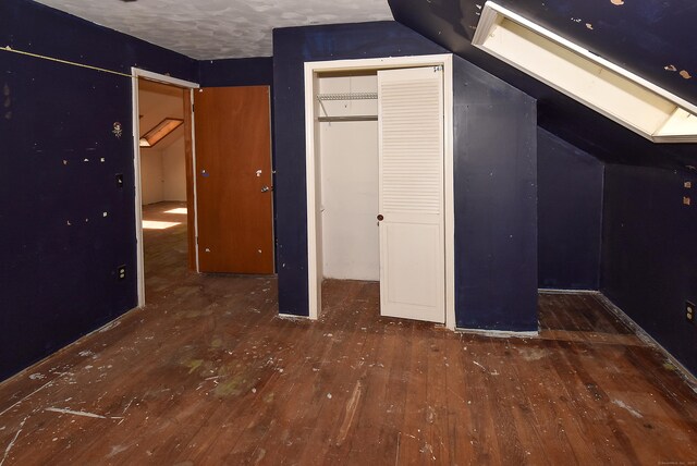 1152 Hartford Tpke, Vernon, CT 06066 - unfurnished bedroom featuring hardwood / wood-style floors, a skylight, and lofted ceiling