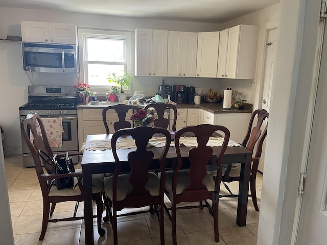 92 Alice St, Bridgeport, CT 06606 - kitchen with appliances with stainless steel finishes, white cabinetry, and light tile patterned floors