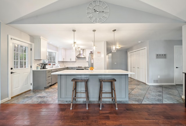 108 Lohse Rd, Willington, CT 06279 - kitchen featuring wall chimney exhaust hood, gray cabinetry, light countertops, vaulted ceiling, and a breakfast bar