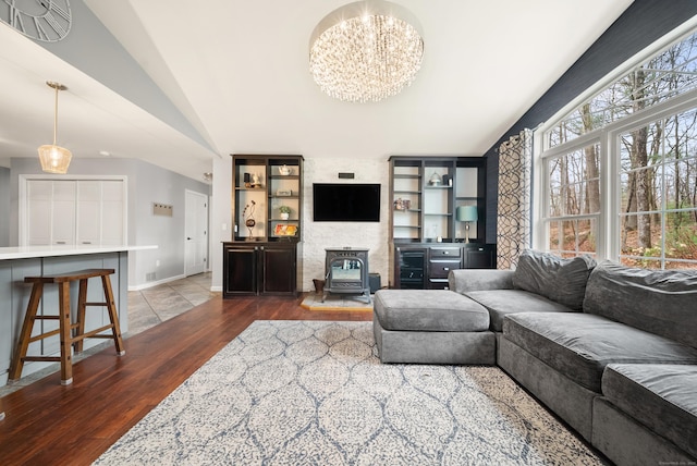 108 Lohse Rd, Willington, CT 06279 - living area with vaulted ceiling, a chandelier, a wood stove, dark wood-type flooring, and baseboards