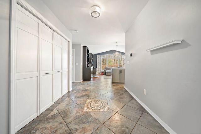 108 Lohse Rd, Willington, CT 06279 - hall with baseboards, stone tile flooring, lofted ceiling, and a chandelier