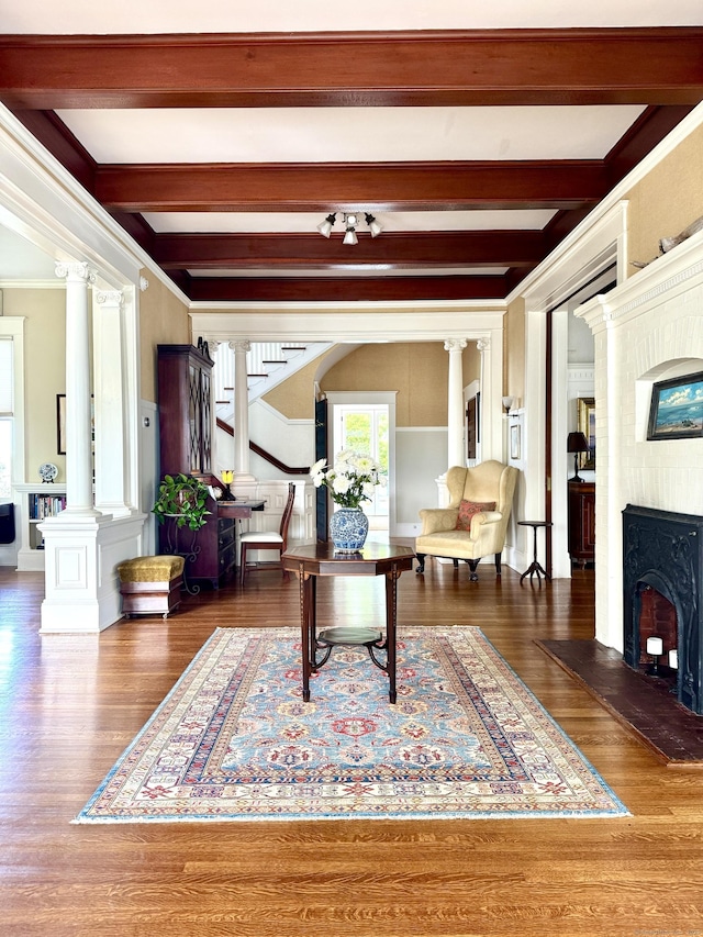 27 Church St, Groton, CT 06340 - living area featuring ornate columns, beam ceiling, a fireplace, ornamental molding, and wood finished floors