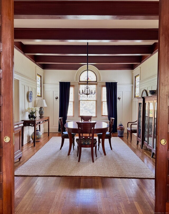 27 Church St, Groton, CT 06340 - dining space featuring a decorative wall, beamed ceiling, dark wood-style flooring, a chandelier, and plenty of natural light