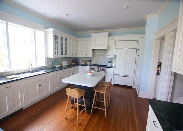 27 Church St, Groton, CT 06340 - kitchen with high quality appliances, a breakfast bar, dark wood-type flooring, glass insert cabinets, and white cabinetry