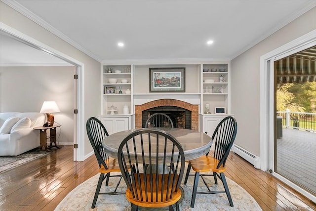 299 W Flat Hill Rd, Southbury, CT 06488 - dining area with hardwood / wood-style floors, a baseboard radiator, baseboards, a brick fireplace, and ornamental molding