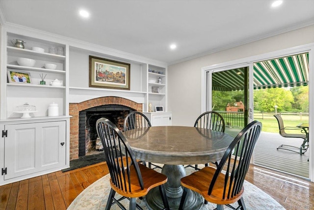 299 W Flat Hill Rd, Southbury, CT 06488 - dining space with built in shelves, ornamental molding, a brick fireplace, dark wood-type flooring, and recessed lighting