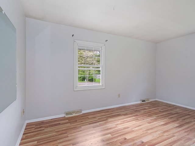 spare room with light wood-style flooring and baseboards