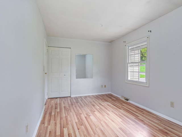empty room featuring light wood finished floors and baseboards