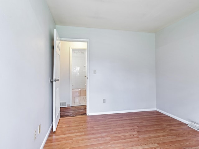 unfurnished room with light wood-style flooring and baseboards