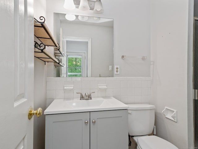 bathroom with vanity, toilet, and tasteful backsplash