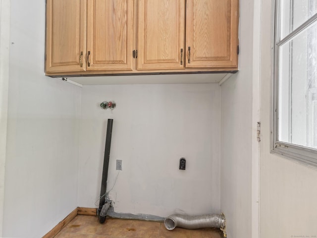 washroom with cabinet space, electric dryer hookup, and baseboards