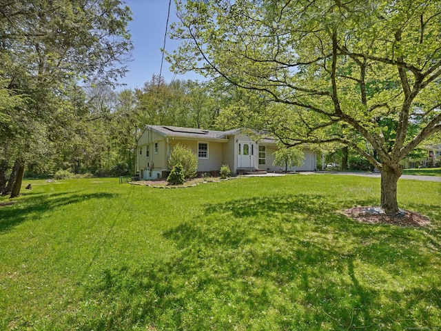 view of green lawn with a garage